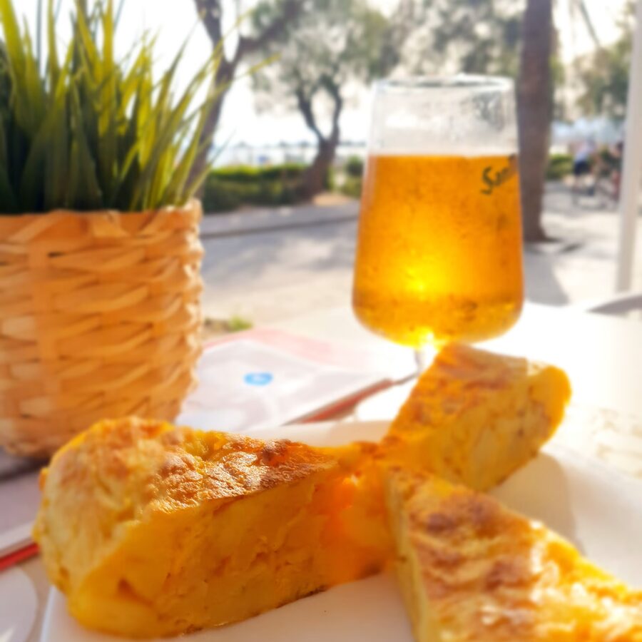 Tortilla española y caña de cerveza frente al paseo marítimo