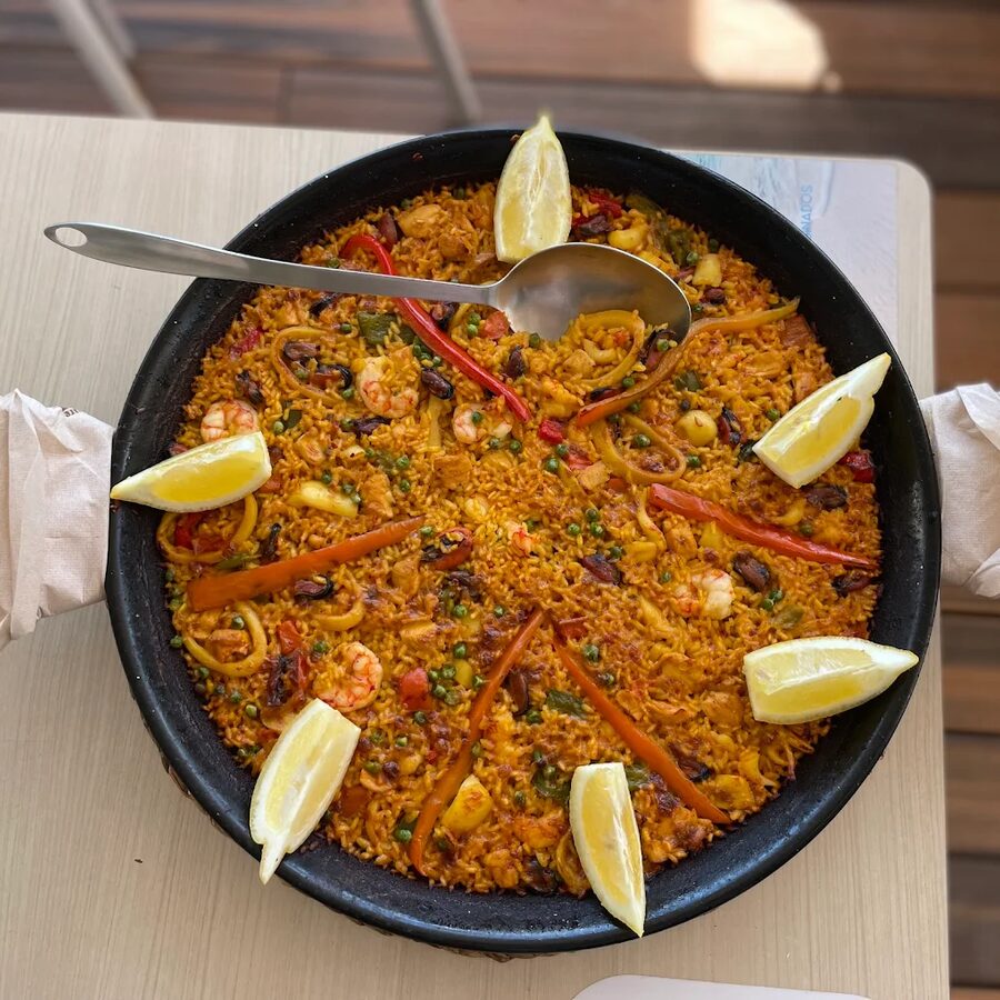 Paella mixta con gambas, calamares y limones recién hecha