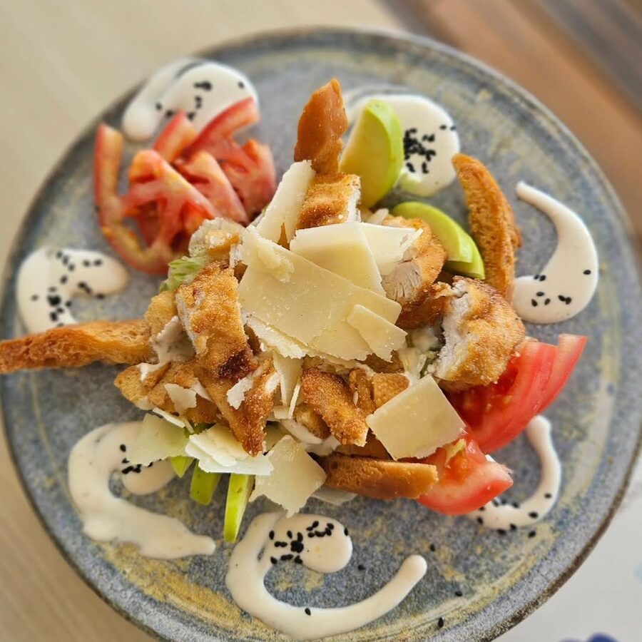 Ensalada César con pollo crujiente, lascas de parmesano y tomate